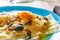 Homemade ravioli with pumpkin on a blue plate partial blur