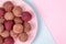 Homemade Raw Energy Balls on Vintage Plate on Blue and Pink Paper Background