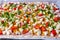 Homemade raw pizza with colorful vegetables and white mozzarella cheese just ready for the oven