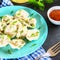 Homemade ready dumplings on a gray concrete table.