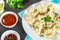 Homemade ready dumplings on a gray concrete table.