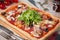 Homemade rectangular pizza on a rustic table