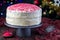 Homemade red velvet cake with cream cheese frosting and red sugar decoration, low key photo with boke lights and christmas