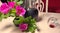 homemade red wine in glass jug, flowers and wine glass on table in room