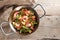 Homemade rice dish with seafood, chicken and vegetables in a paella pan on rustic wooden planks, copy space, high angel view from