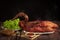 Homemade Roast Peking duck and vegetables on rustic wooden table, Chinese style on black background