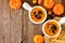 Homemade roasted autumn vegetable soup in onion soup bowls, top view corner border on a rustic wood background with copy space