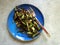 Homemade roasted broccoli with pine nuts served on blue plate