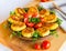 Homemade ruddy cheese and potato cutlets, decorated with fresh tomatoes and parsley, in ceramic plate on wooden board