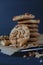 Homemade ruddy cookies with nuts lie pyramid on baking paper on a dark background