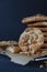 Homemade ruddy cookies with nuts lie pyramid on baking paper on a dark background