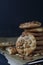 Homemade ruddy cookies with nuts lie pyramid on baking paper on a dark background