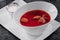 Homemade Russian, Ukrainian and Polish national soup - red borscht made of beetroot, vegetables and meat with sour cream