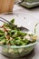 Homemade Salad with Pomegranate Seeds and Herbal Plant Root Sauce Mixed with Two Spoon in Glass Bowl