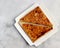 Homemade samosa on a white rectangular plate on a light gray background