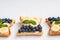 Homemade sandwiches with cottage cheese, blueberries, banana, mint on a white background, copy space