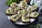 Homemade sandwiches with kiwi, herring, cream cheese and garlic on white plate on a dark gray background. Close-up