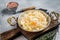 Homemade sauerkraut with black pepper and salt in a skillet. Gray background. Top view