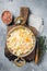 Homemade sauerkraut with black pepper and salt in a skillet. Gray background. Top view