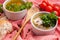 Homemade sausage soup with sour cream and parsley in white ramekin bowls