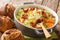 Homemade savoy cabbage soup with fried bacon served with bread close-up in a bowl. horizontal