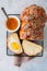 Homemade sesame seeds challah bread and orange jam on a wire rack a white background.