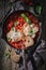 Homemade shakshuka with eggs, tomatoes and herbs