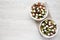 Homemade Shepards salad with cucumbers, feta and parsley in white bowls on a white wooden background, top view. From above,