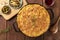Homemade Shepherd`s pie with pickles and wine on a rustic background, overhead shot