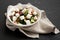 Homemade Shepherds salad with cucumbers, parsley and feta in a white bowl on a black background, side view. Closeup