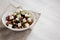 Homemade Shepherds salad with cucumbers, parsley and feta in a white bowl on a white wooden surface, side view. Copy space
