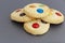 Homemade shortbread cookies with multicolored chocolate chips and icing powdered on gray background.