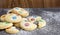 Homemade shortbread cookies with multicolored chocolate chips and icing powdered on gray background. Selective focus.