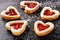 Homemade shortbread heart cookies on black background.