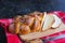 Homemade sliced challah, traditional wicker white bread on a wooden board on a black concrete background