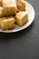 Homemade Sliced Cornbread Ready to Eat on a white plate on a black background, side view. Copy space