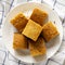 Homemade Sliced Cornbread Ready to Eat on a white plate, top view. Flat lay, overhead, from above. Closeup