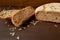 Homemade sliced fresh bread with sunflower seeds on the wooden background ready to eat. Just baked tasty bread on the brown table