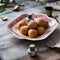 Homemade small round ball donuts sprinkled with powdered sugar on vintage plate