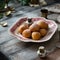 Homemade small round ball donuts sprinkled with powdered sugar on vintage plate