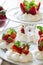 Homemade small strawberry pavlova meringue cakes with mascarpone cream and fresh mint leaves