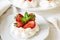 Homemade small strawberry pavlova meringue cakes with mascarpone cream and fresh mint leaves