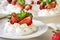 Homemade small strawberry pavlova meringue cakes with mascarpone cream and fresh mint leaves