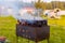 Homemade smokehouse on fire. The fire burns under a metal box for smoking, standing in the grill. Smoking method