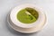 Homemade soup puree of green peas, coconut milk with tuil and cheese quenelle