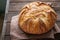 Homemade sourdough bread in a wooden tray on a wooden background