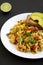 Homemade southwestern egg scramble with toast on a white plate on a black background, side view. Close-up