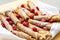 Homemade stack of rolled french crepes with powdered sugar icing raspberries designed on a plate for breakfast or a snack