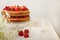 Homemade strawberry cake on a glass stand on the white background.