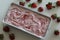 Homemade strawberry ice cream taken out from freezer in a loaf tin. Three ingredient ice cream made of fresh strawberries, heavy